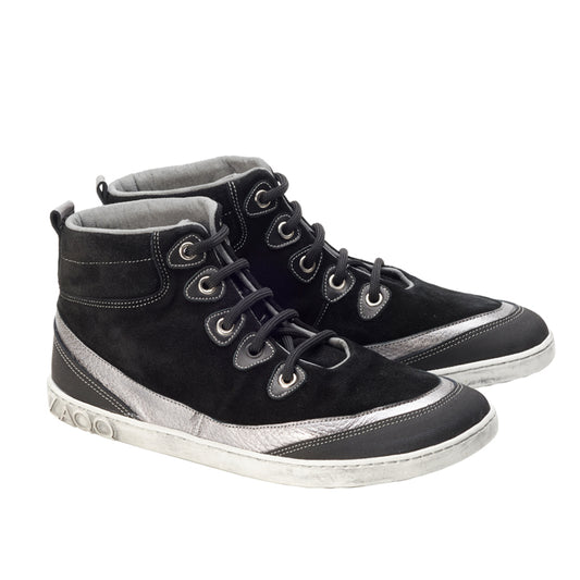 Die High-Top-Sneaker FRANQY Black von ZAQQ haben weiße Sohlen und eine Kombination aus Wildleder und glatten Texturen. Sie sind mit Metallösen und markanten Nähmustern versehen. Diese Midcut-Sneaker von ZAQQ werden auf einem weißen Hintergrund präsentiert.