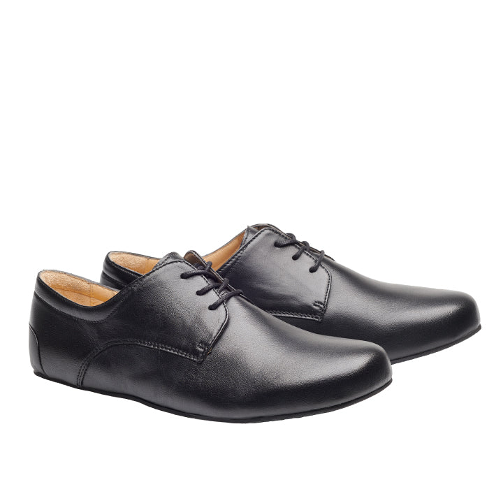 Vor weißem Hintergrund verkörpern die IQON Black Schuhe von ZAQQ den Derby-Schnitt-Stil. Mit ihrer glatten, polierten Oberfläche und dem Schnürdesign sind sie die perfekte Ergänzung zu einem eleganten Business-Outfit für formelle Anlässe.