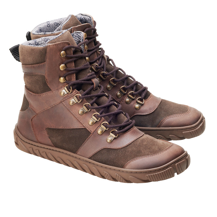 Der ZAQQ EXPLORER Brown Waterproof ist ein High-Top-Schuh aus Leder und Wildleder, mit Messingösen und dicken Gummisohlen. Diese Wanderstiefel sind geschnürt und zeigen sowohl die Seiten- als auch die Vorderansicht aus einem Winkel.