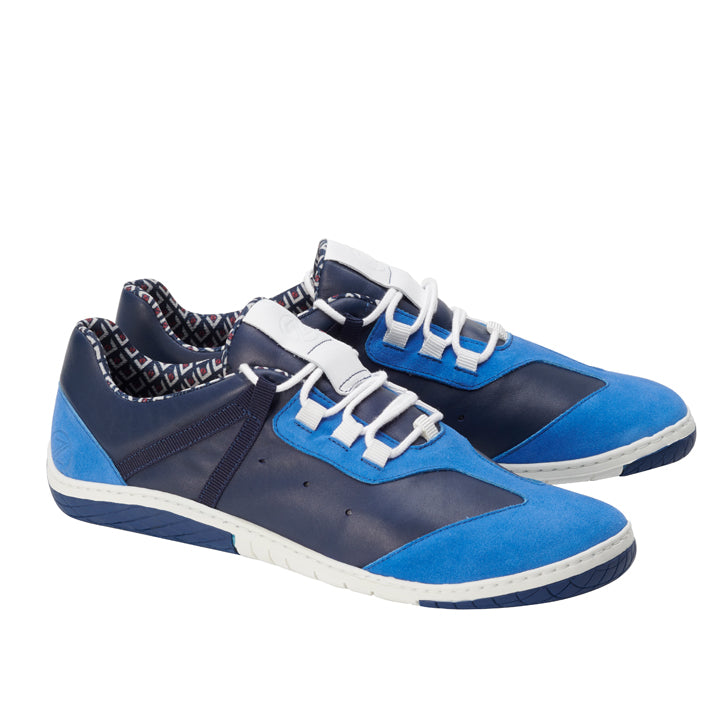 Wir präsentieren den ZAQQ QOAST Blue: Diese Sneaker bestechen durch eine Mischung aus Blau und Marineblau mit weißer Sohle und kontrastierenden Schnürsenkeln. Sie sind aus Nappaleder gefertigt, haben ein geometrisch gemustertes Innenfutter und die ZAQQ MINIMAL Sohle und bieten einen zeitgenössischen Stil und gleichzeitig den Komfort eines Barfußschuh-Designs.