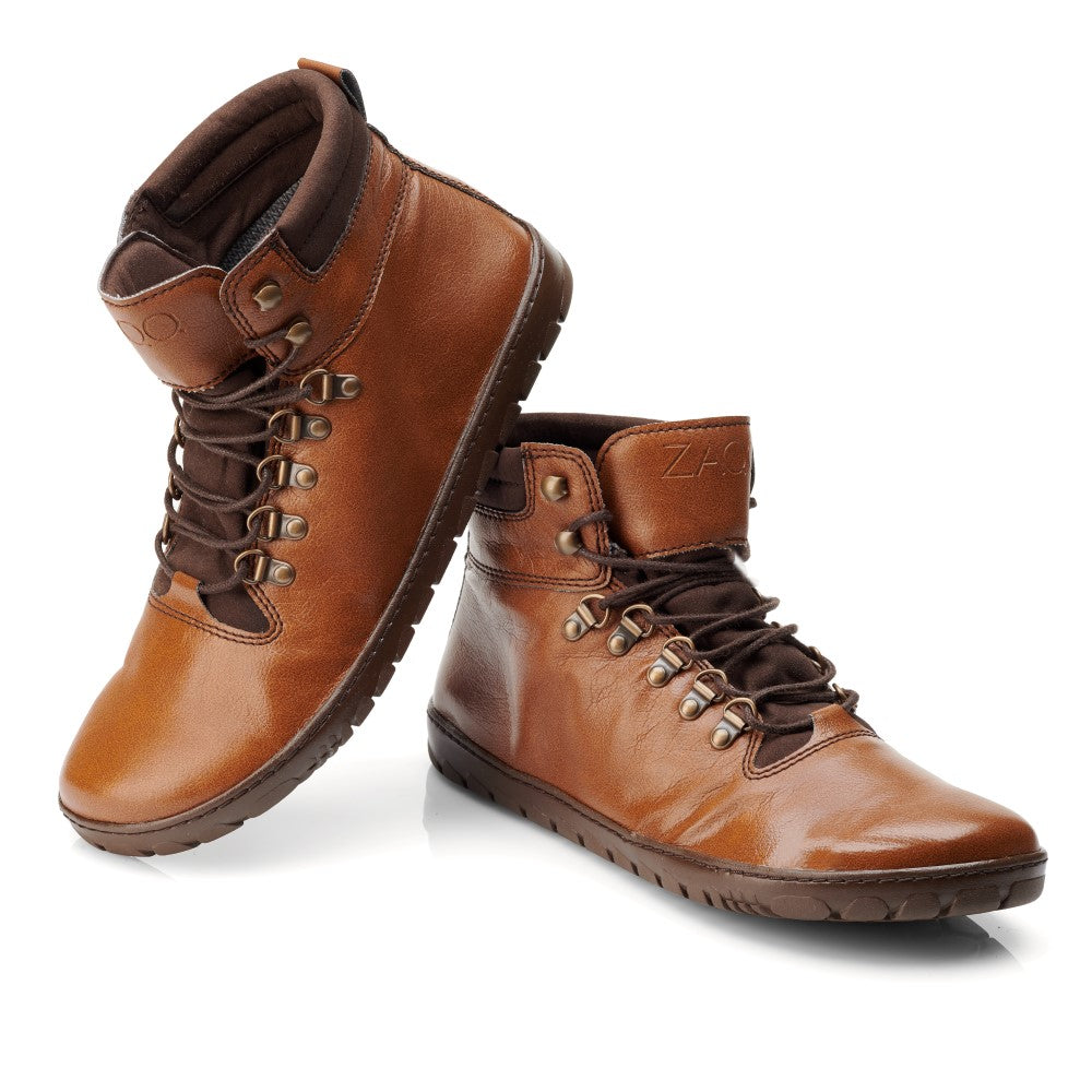 Die EXPEQ Vegan Cuoio Waterproof-Stiefel von ZAQQ strahlen robuste Eleganz aus und zeichnen sich durch ein stilvolles braunes Finish, dunkelbraune Schnürsenkel, Metallösen und einen gepolsterten Knöchelkragen aus. Diese wasserdichten Stiefel verfügen über eine Gummisohle mit robustem Profilmuster. Ein Stiefel ist leicht erhöht, um sein Seitenprofil zu präsentieren, wodurch das ZAQQ-Branding in der Nähe des Knöchels dezent hervorgehoben wird.