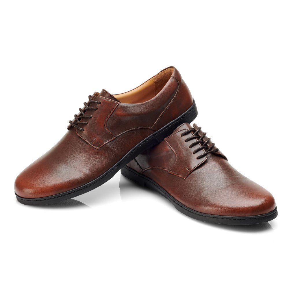 Ein Paar polierte BRIQ Antique Brown Abendschuhe von ZAQQ, mit dunklen Schnürsenkeln und einem Schuh auf dem anderen. Das klassische Businessschuh-Design bietet ein glattes Finish und macht sie ideal für formelle Anlässe.