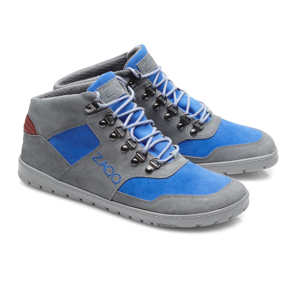 Wir präsentieren den HIQE Mid Azure Waterproof von ZAQQ: Diese High-Top-Sneakers bestechen durch graue und blaue Einsätze, ergänzt durch blaue Schnürsenkel und schwarze Metallösen. Sie sind aus Veloursleder gefertigt und verfügen über Steppnähte, ein Branding an der Seite und eine strukturierte Outdoorsohle für optimalen Halt.