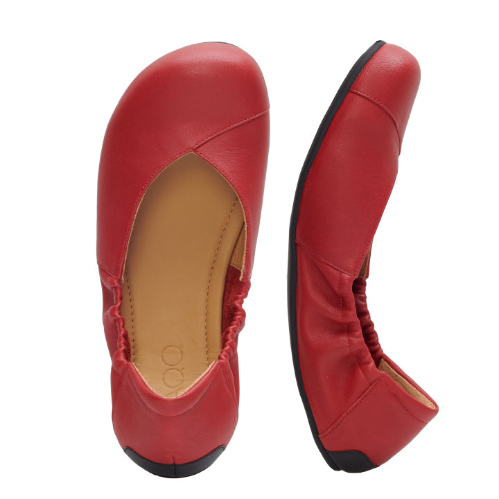 Ein Paar MAIQA Red Ballerinas von ZAQQ aus weichem Nappaleder mit leicht abgerundeter Spitze, elastischer Ferse und schwarzer Sohle. Ein Schuh ist von oben und der andere von der Seite zu sehen, um das minimalistische und elegante Barfußschuhdesign hervorzuheben.