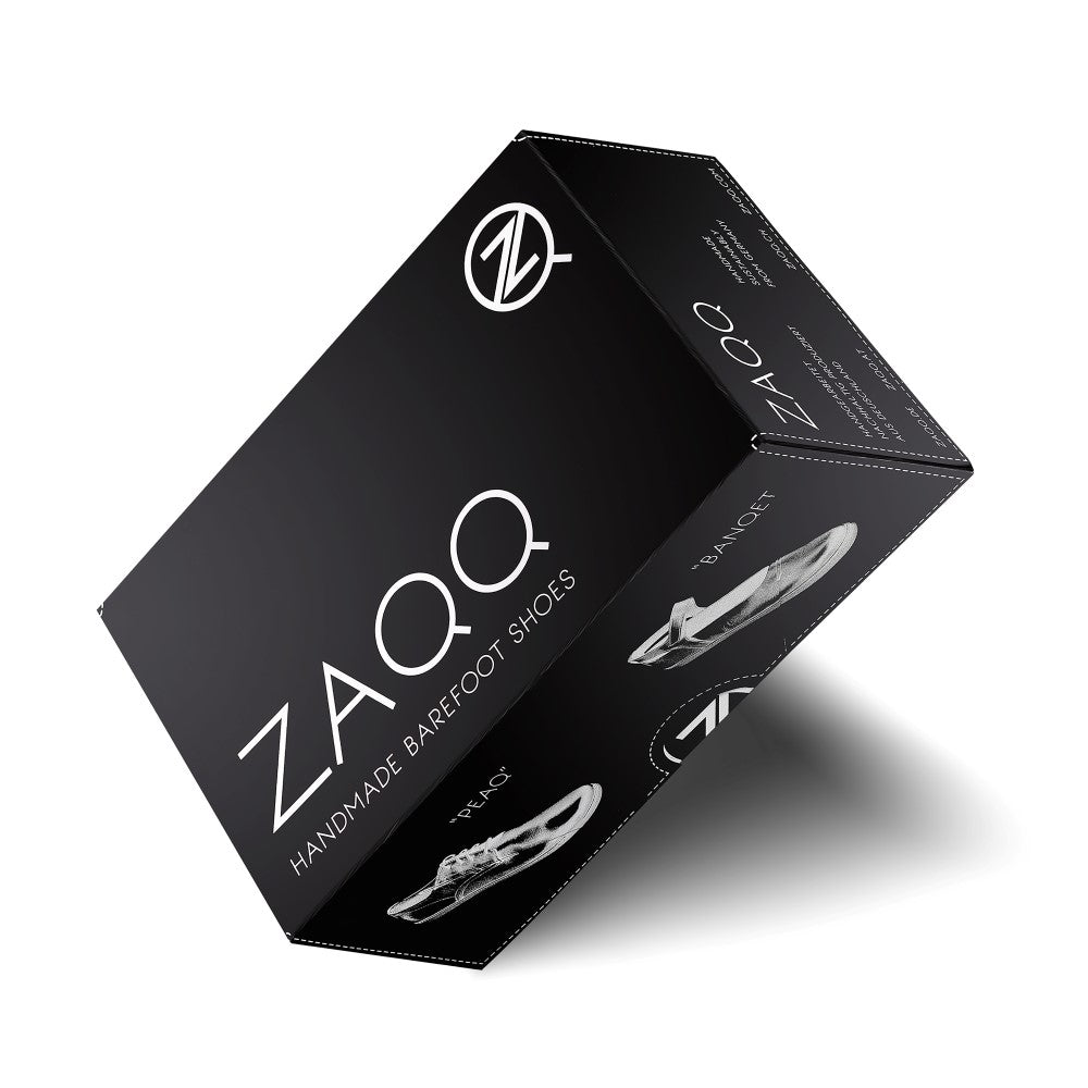 Seitenansicht eines Paars BRIQ Brogue Waterproof Black von ZAQQ, aus schwarzem Leder gefertigt und mit dekorativen Perforationen für einen zeitlosen Look.