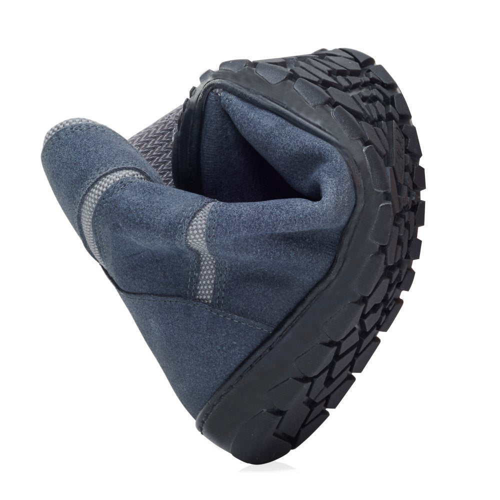 Der DAQOTA Waterproof Grey von ZAQQ, ein vielseitiger schwarz-grauer Schuh, ist gebogen dargestellt, um seine Flexibilität zu demonstrieren. Dieser Outdoor-Schuh verfügt über eine robuste Sohle mit strukturiertem Griffmuster und ist aus weichem Stoffmaterial gefertigt, das sowohl Komfort als auch Haltbarkeit für verschiedene Abenteuer bietet.