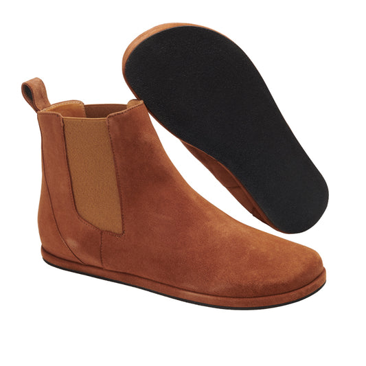 Ein Paar EQUITY Chelsea-Stiefel aus Cognac-Veloursleder von ZAQQ mit elastischen Seitenteilen und schwarzen Sohlen, wobei ein Stiefel aufrecht steht und der andere auf der Seite liegt, sodass die Sohle sichtbar ist.