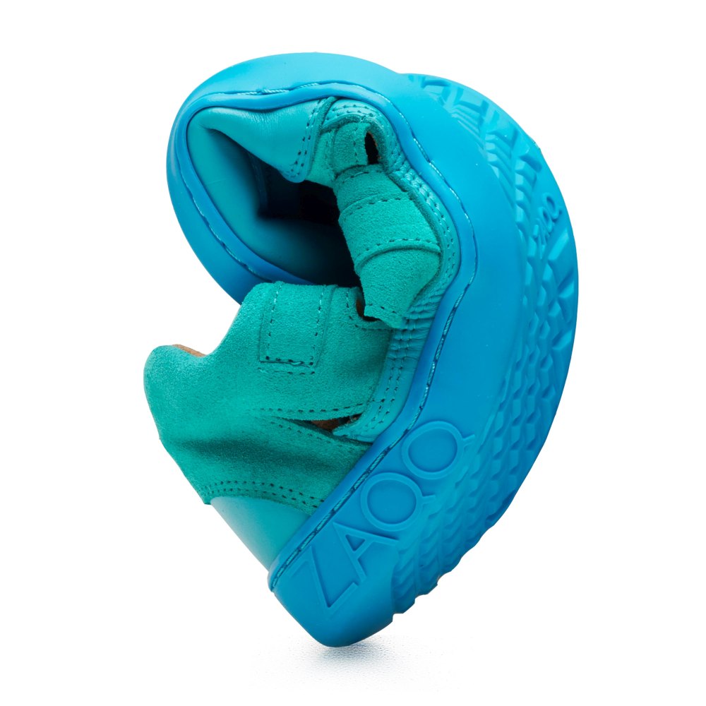 Der QLEAR Turquoise von ZAQQ lässt sich in der Mitte biegen und zeigt so seine Flexibilität. Dieser Barfußschuh verfügt über eine strukturierte Sohle und einen Riemenverschluss, auf deren Seite das ZAQQ-Logo eingeprägt ist.