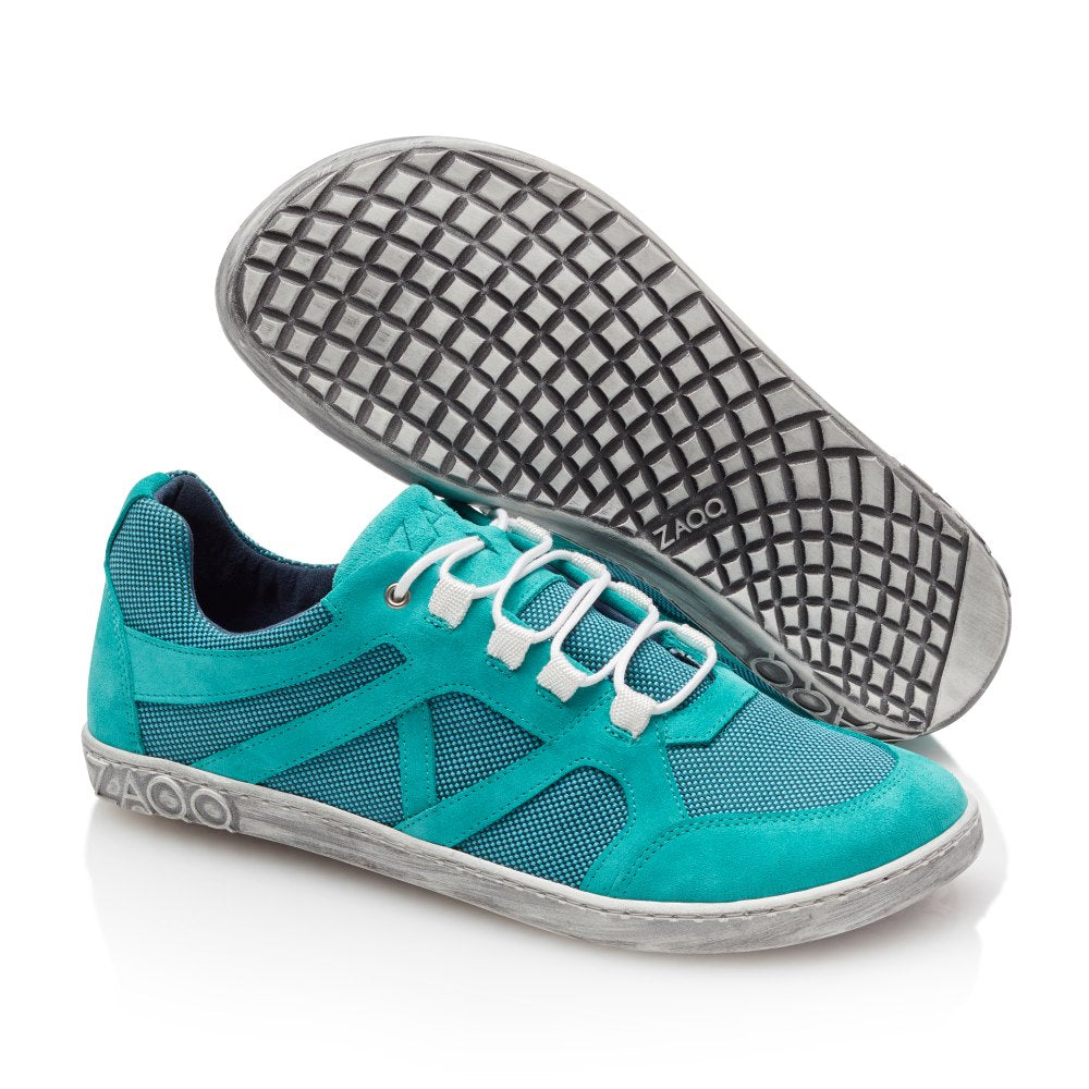 Wir präsentieren die ZAQQ QUSQO Turquoise Sneaker mit ihrem lebendigen Türkiston und den klassischen weißen Schnürsenkeln, die sie zu Ihrem idealen Laufpartner machen. Ein Schuh steht aufrecht, während der andere sich neigt und die einzigartige Sohle mit Gittermuster freigibt. Diese Sneaker bestechen durch eine Kombination aus Mesh- und Wildledertexturen und bieten ein atmungsaktives und flexibles Design, das perfekt für jedes Abenteuer ist.