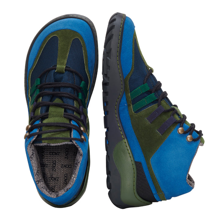 Ein lebhaftes Paar ZAQQ SQOUT Blue Green Waterproof-Schuhe mit blauen, grünen und schwarzen Akzenten. Ein Schuh steht aufrecht und betont sein Seitenprofil mit der robusten ZAQQ TERRA-Sohle, während der andere auf der Seite liegt und die Draufsicht zeigt. Die Schuhe sind mit Schnürsenkeln ausgestattet und verfügen über eine wasserdichte Membran.