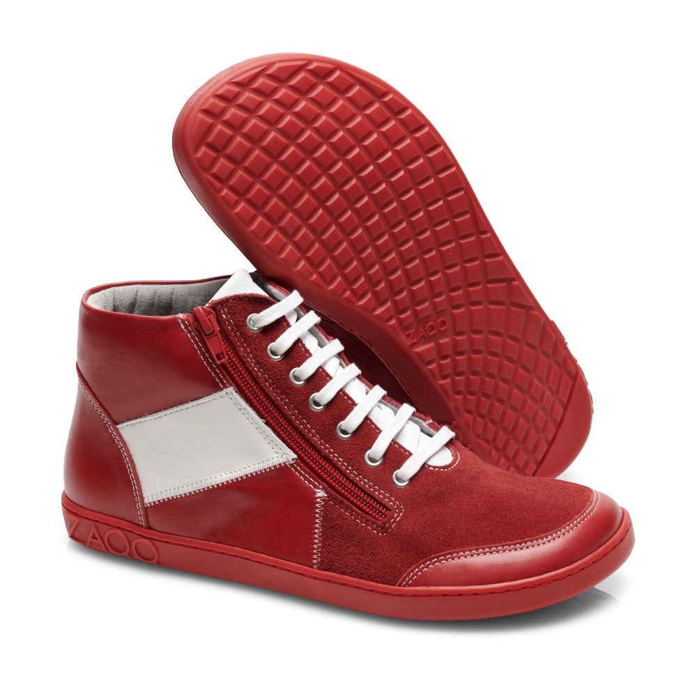 Wir präsentieren den LUQQ Red von ZAQQ: Dieses Paar roter High-Top-Sneaker besticht durch weiße Akzente, seitliche Reißverschlüsse und eine flexible Kautschuksohle. Das Design umfasst rote Gummisohlen, passende rote Schnürsenkel und einen markanten weißen geometrischen Patch. Ein Schuh steht aufrecht, während der andere auf der Seite liegt, um das komplizierte Sohlenmuster hervorzuheben.